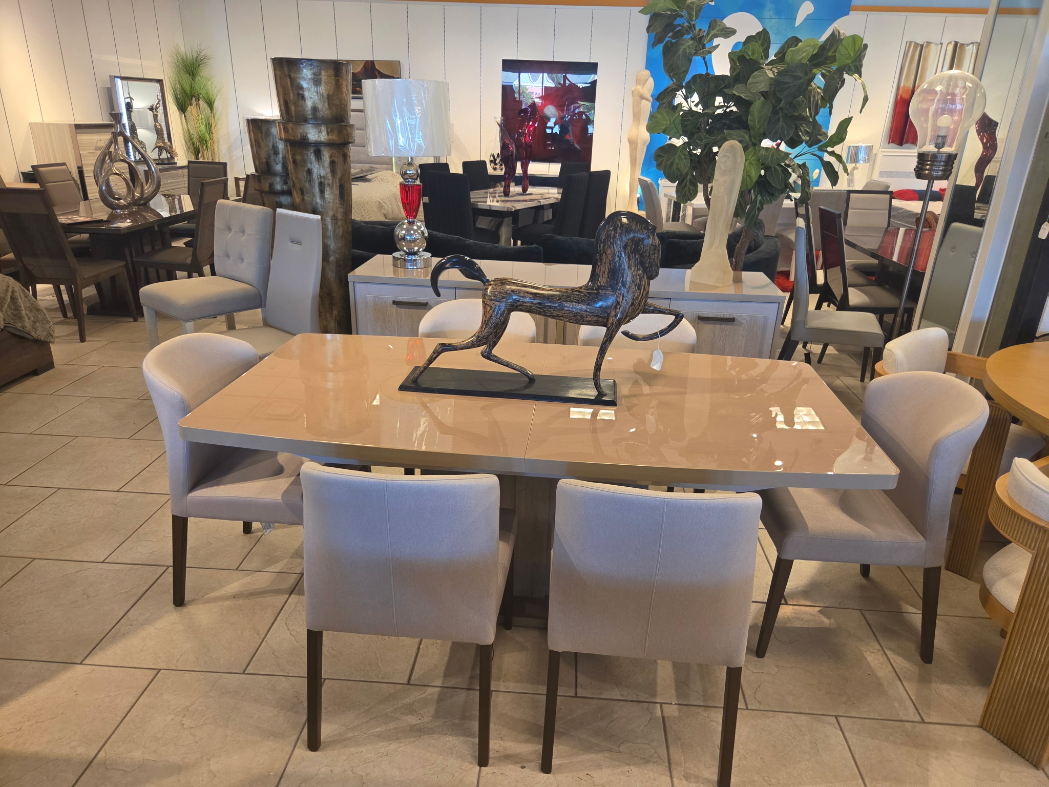 Gloss dining table with light upholstered dining chairs in the Riverhead showroom