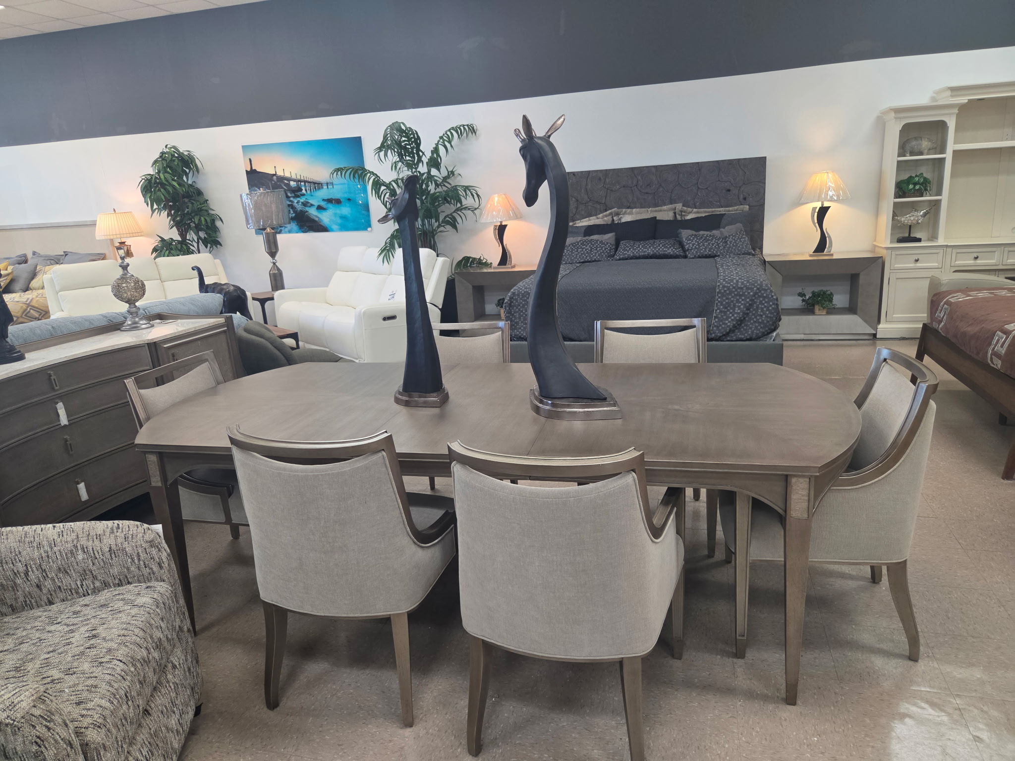 Gray dining table with upholstered chairs in the Riverhead showroom